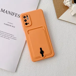 Détail de coque de téléphone en silicone orange avec poche porte-cartes et bague support.