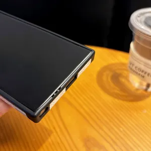 Detailed view of the phone case bottom ports and textured side strip on a wooden table.