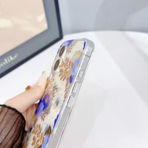 Vista dettagliata della custodia trasparente per telefono con stampa floreale blu e marrone.