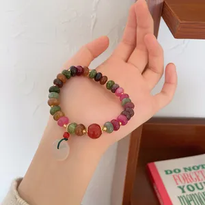 Detailed view of vintage colorful tourmaline gemstone bead bracelet with jade peace buckle.