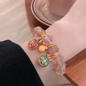 Sweet pink glass rose bead bracelet detail, featuring cute gold beast charms for women.
