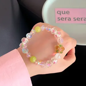 Close-up detail of sweet crystal beaded bracelet with glass rose and flower charms.