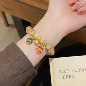 Detailed close-up shot of colorful glazed bead bracelet with cute animal charms on wrist.