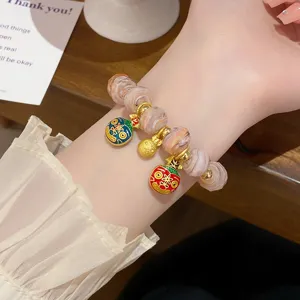 Detailed view of a sweet glass beaded bracelet with lucky beast charms on a delicate wrist.