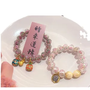 Sweet pink glass rose bead bracelet set with cute gold charms for women and girls.