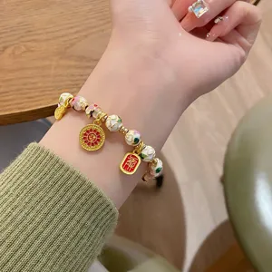Detail du bracelet de perles en email cloisonne de style chinois avec charme traditionnel.