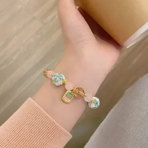 Vue détaillée du bracelet élégant en perles de fleurs glacées avec des cristaux roses.