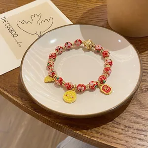 Bracelet de perles émaillées cloisonné traditionnel chinois avec des amulettes de chance.