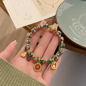 Gros plan détail du bracelet de perles en émail cloisonné de style chinois avec breloques.