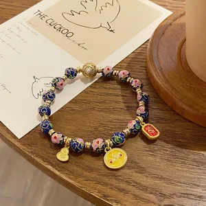 Vue detaillee de bracelet de perles en email cloisonne de style chinois avec pendentifs.