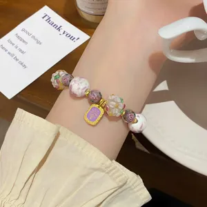 Gros plan détaillé d'un bracelet en perles de verre floral, style de niche doux et élégant.