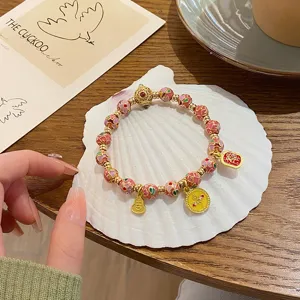 Vue de detail du bracelet de perles en email cloisonne de style chinois avec des pendentifs.
