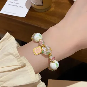 Élégant bracelet en perles de verre florales avec accents dorés, bijoux de poignet style fée.