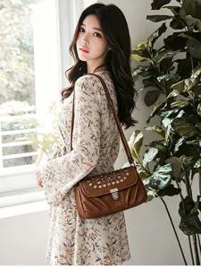 Retro brown leather shoulder bag detail, stylish metal studs and lock, elegant daily wear