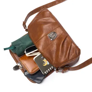 Brown vintage leather shoulder bag detail showing interior capacity and daily items.