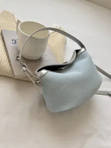Light blue shoulder bag with silver trim, hobo style cloud bag featuring adjustable strap details.