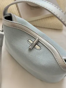 Light blue denim shoulder bag with silver trim and metal twist-lock for women daily use.