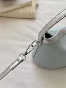 Close-up detail view of light blue denim shoulder bag with silver hardware and leather strap.