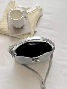 Detail view of the stylish silver shoulder handbag showcasing metallic clasp and texture.