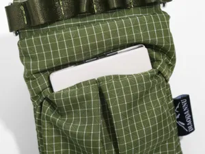 Close-up detail of green grid tactical shoulder bag pocket, durable fabric and strap design.