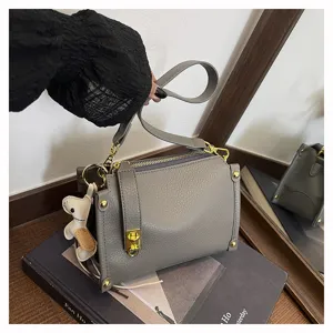 Stylish grey leather crossbody bag for women with wide strap and large capacity storage.