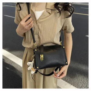 Black PU leather crossbody bag for women, wide strap, chic metal lock and cute charm.