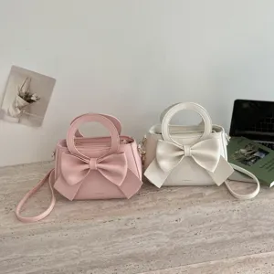 Sweet bow handbag and shoulder bag detail view featuring elegant round handles and soft PU leather.