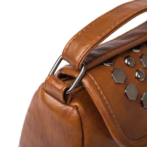 Detailed view of brown leather vintage women shoulder bag strap and metal hardware studs.