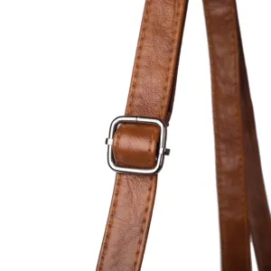 Close-up detail of a brown leather bag strap with an adjustable silver metal buckle.