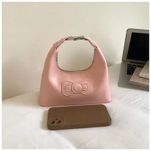 Pink underarm hobo bag detail shot, featuring cute 3D bow and metal buckle handle.