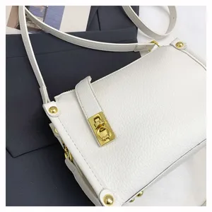 White leather crossbody bag detail, chic square handbag with gold hardware and stylish clasp.