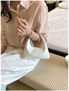 White underarm bag detail view, elegant bow design, sleek PU leather finish for daily wear.