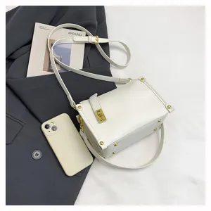 Detail shot of white PU leather crossbody bag with wide strap and metal lock closure.