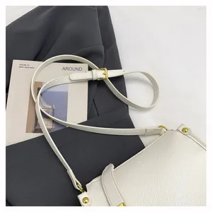 Chic white leather crossbody bag detail, premium gold tone hardware and adjustable strap.