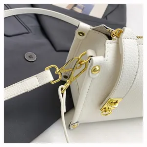 Close-up detail of white shoulder bag with gold-tone hardware and adjustable strap design.