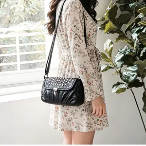 Detailed view of the stylish retro black leather crossbody shoulder bag with metal studs.
