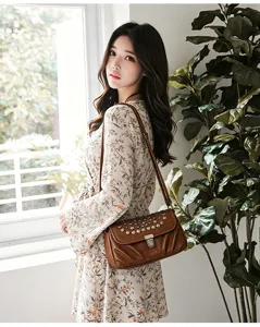 Close-up view of the retro brown leather women shoulder bag detail featuring metal studs.