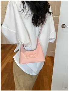 Detail view of the pink shoulder underarm bag featuring a cute embossed bow and strap.