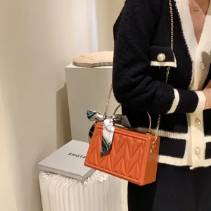 Trendy Korean style orange box shoulder bag with chic silk scarf and metal chain strap.