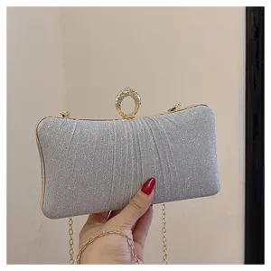 Silver glitter evening clutch bag with rhinestone ring clasp and gold chain strap detail.