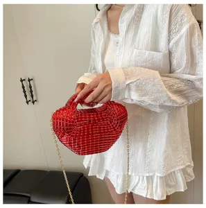 Glossy red acrylic dumpling bag detail shot, featuring metallic gold chain strap and unique texture.