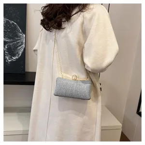 Stunning silver sequin evening clutch bag with elegant clasp closure and chain strap for women.