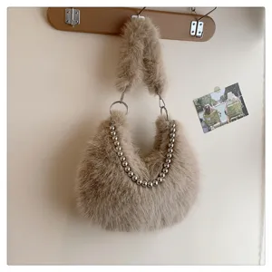 Detail view of khaki faux fur underarm shoulder bag with metal bead chain and ring.