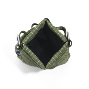 Detailed top view of a green grid tactical shoulder bag, featuring durable fabric and metal rings.