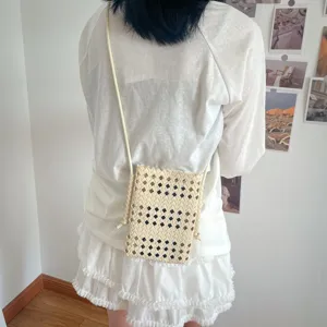 Vista dettagliata di una elegante borsetta a tracolla beige intrecciata con stile.