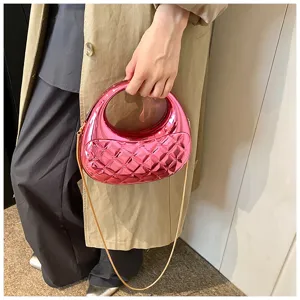 Detail shot of pink metallic quilted acrylic evening bag with gold chain strap and round handle.