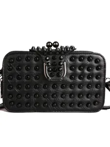 Sac bandoulière clouté en cuir souple style punk noir avec fermoir métallique et détails de rivets.