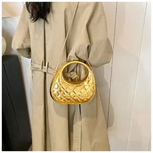 Shiny gold metallic quilted crossbody bag with stylish circular handle for women fashion.