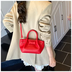 Red leather bucket bag featuring chic bow and metal ring details for elegant casual daily wear.