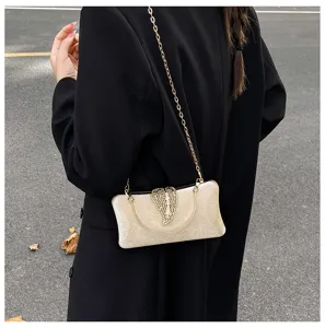 Elegant gold evening bag detail showcasing exquisite hollow leaf clasp and delicate chain strap.